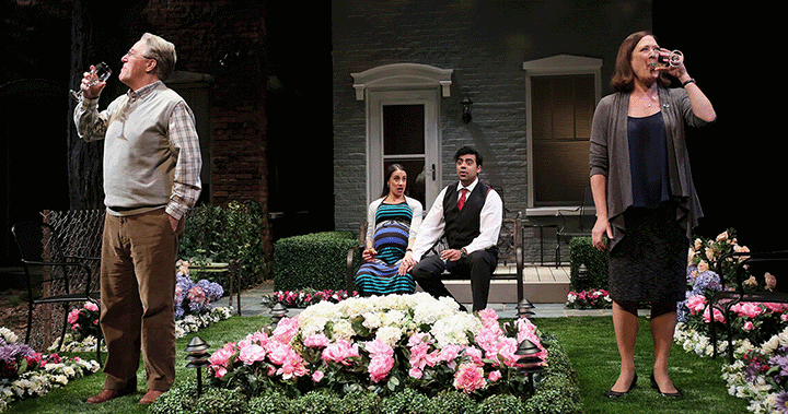 Old white people drinking wine, while a a young brown couple sit in the center of them looking uncomfortable.